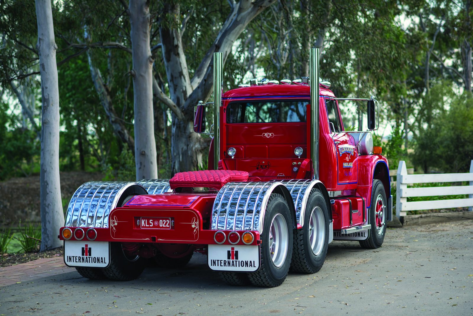 Rear view of Phil Ellbourn’s restored red International Loadstar beneath trees