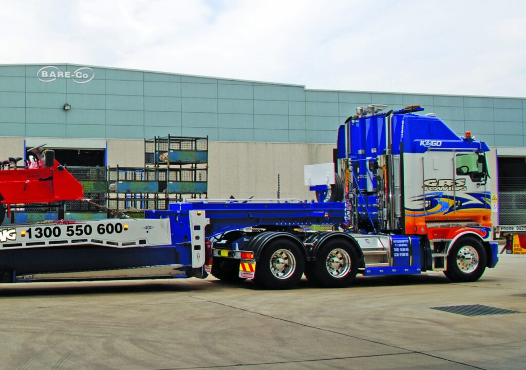 Side view of GRS Towing’s blue Kenworth K200 carrying red recovery equipment