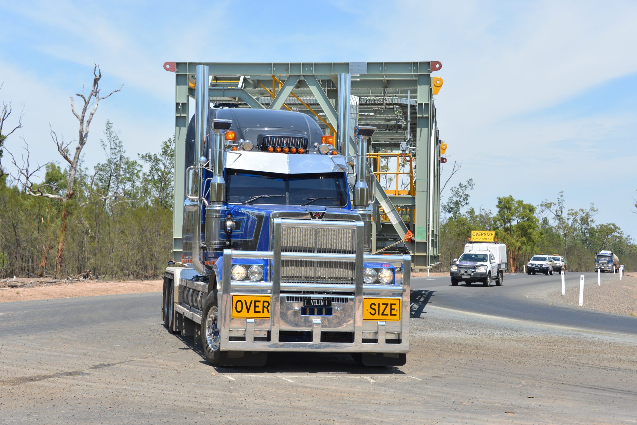 Head-on view of blue HHA Western Star 6900 Butch Cassidy showing the King Bars bullbar and oversized load