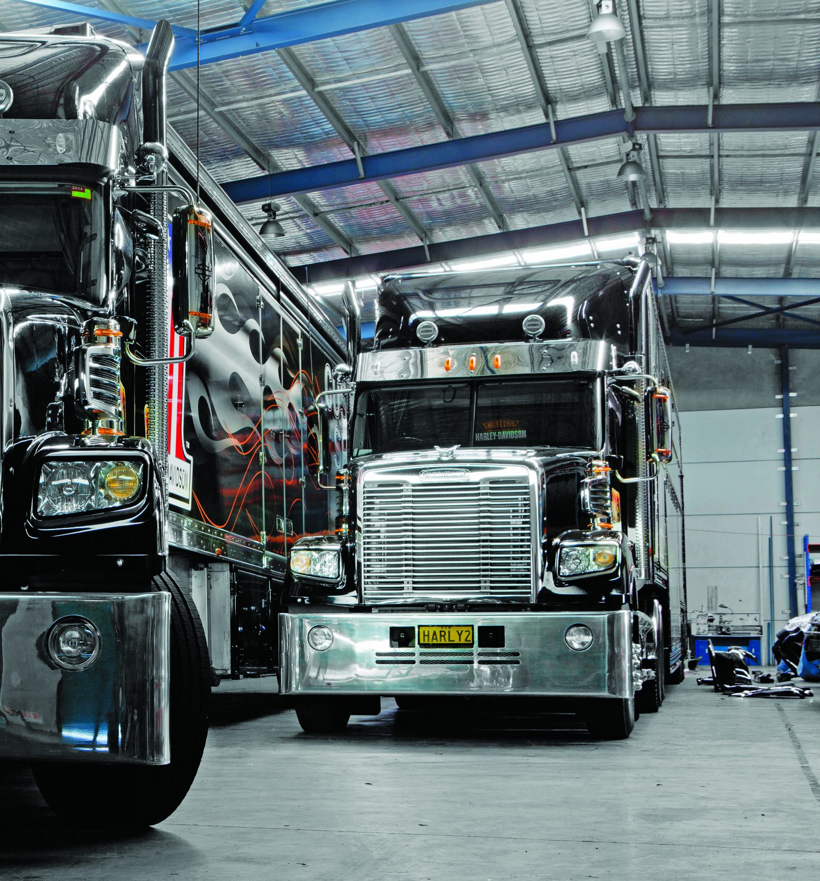 Two customised Freightliner Coronado trucks inside a workshop
