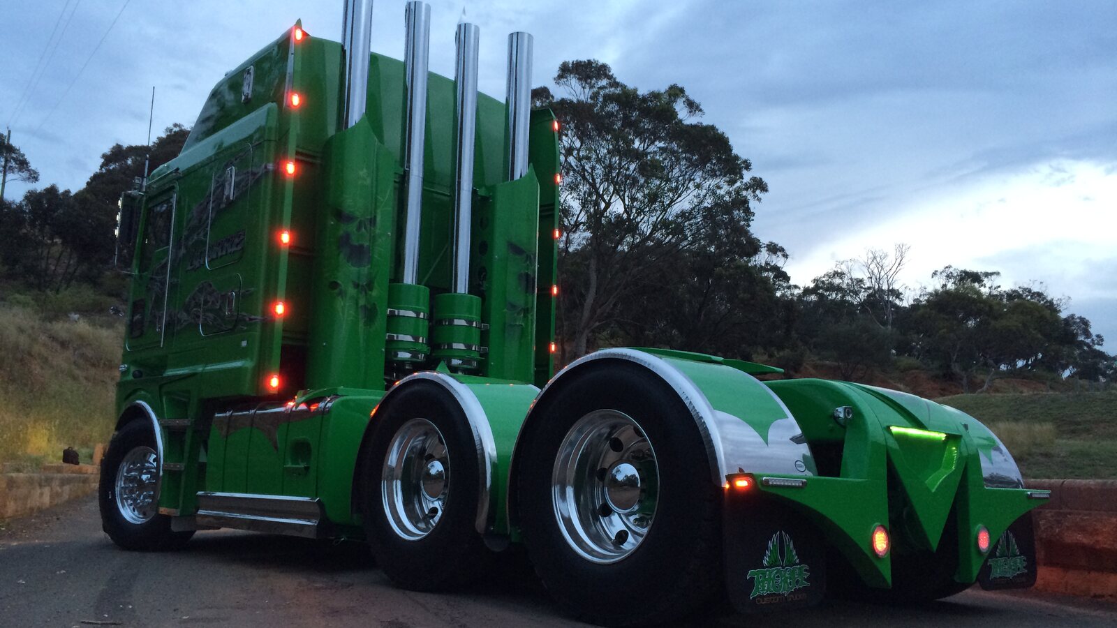 Rear three-quarter view of Anthony Latorre’s green custom Kenworth K200 with four polished exhaust stacks