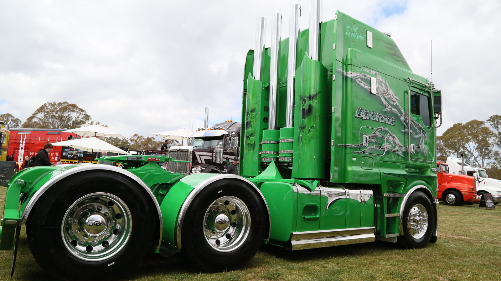 Side view of Anthony Latorre’s green Kenworth K200 showing the airbrushed sleeper and polished wheels