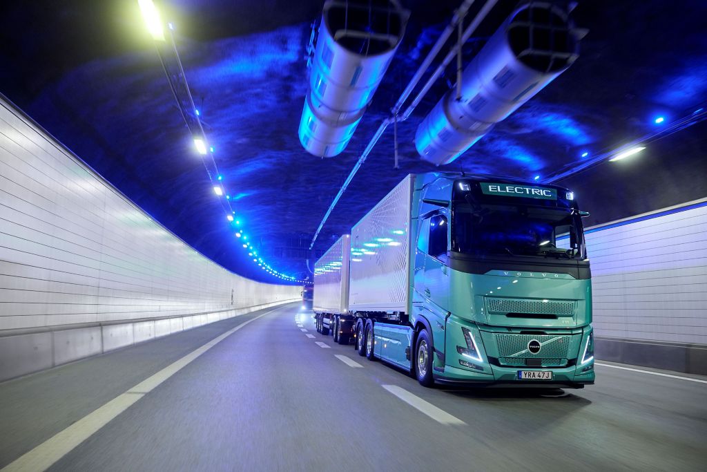 Green Volvo FH Aero Electric rigid truck and trailer travelling through a tunnel.