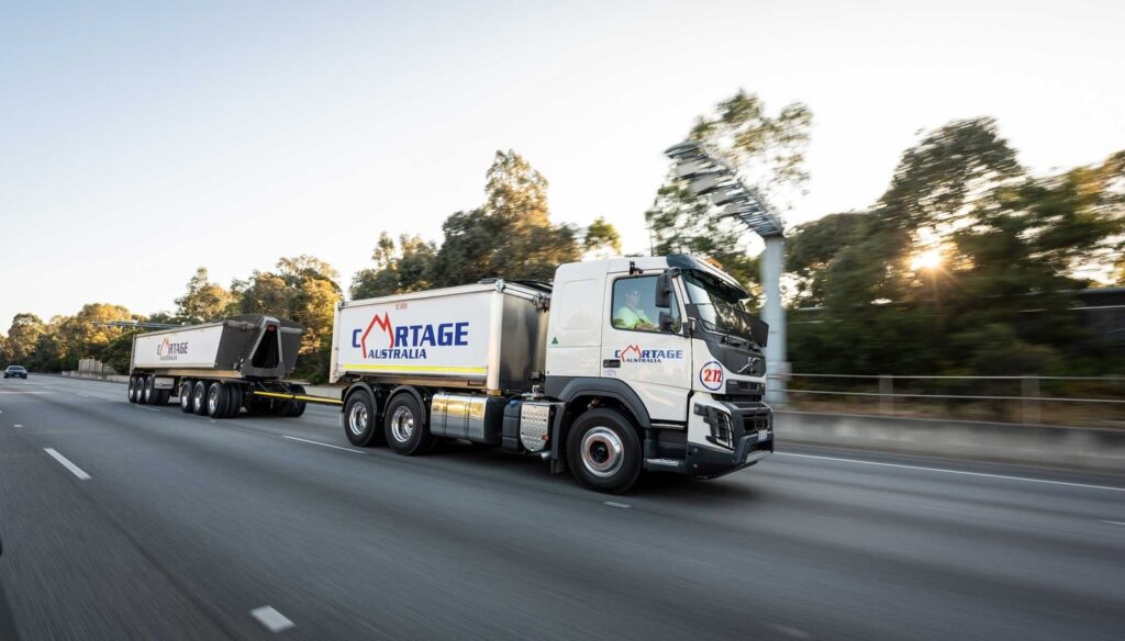 Cartage Australia-branded truck and tipper combination travelling on a road.