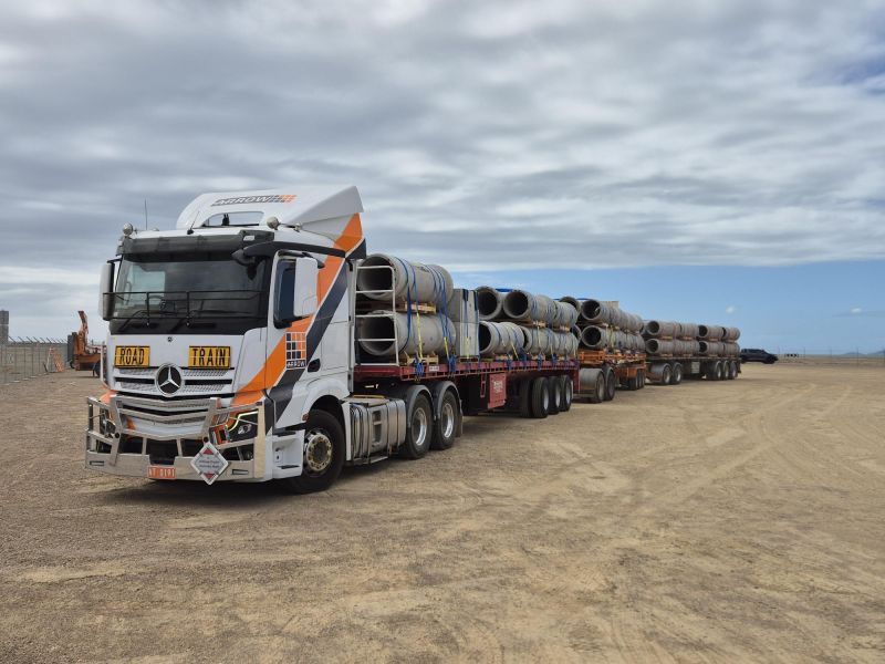 Arrow Transport prime mover hauling three flatbed trailers loaded with pipes for Speedlink Logistics’ Mount Isa project.