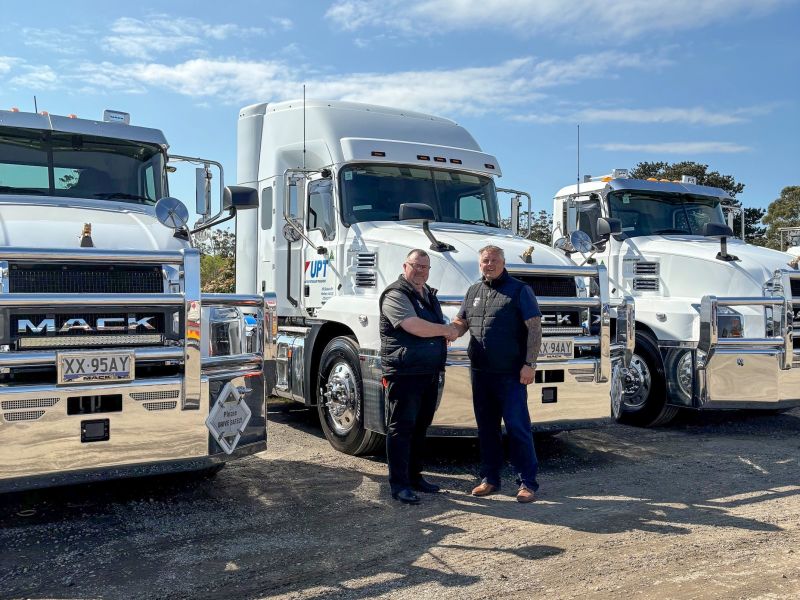 Two men shake hands in front of white Mack Anthem trucks at United Petroleum’s handover.